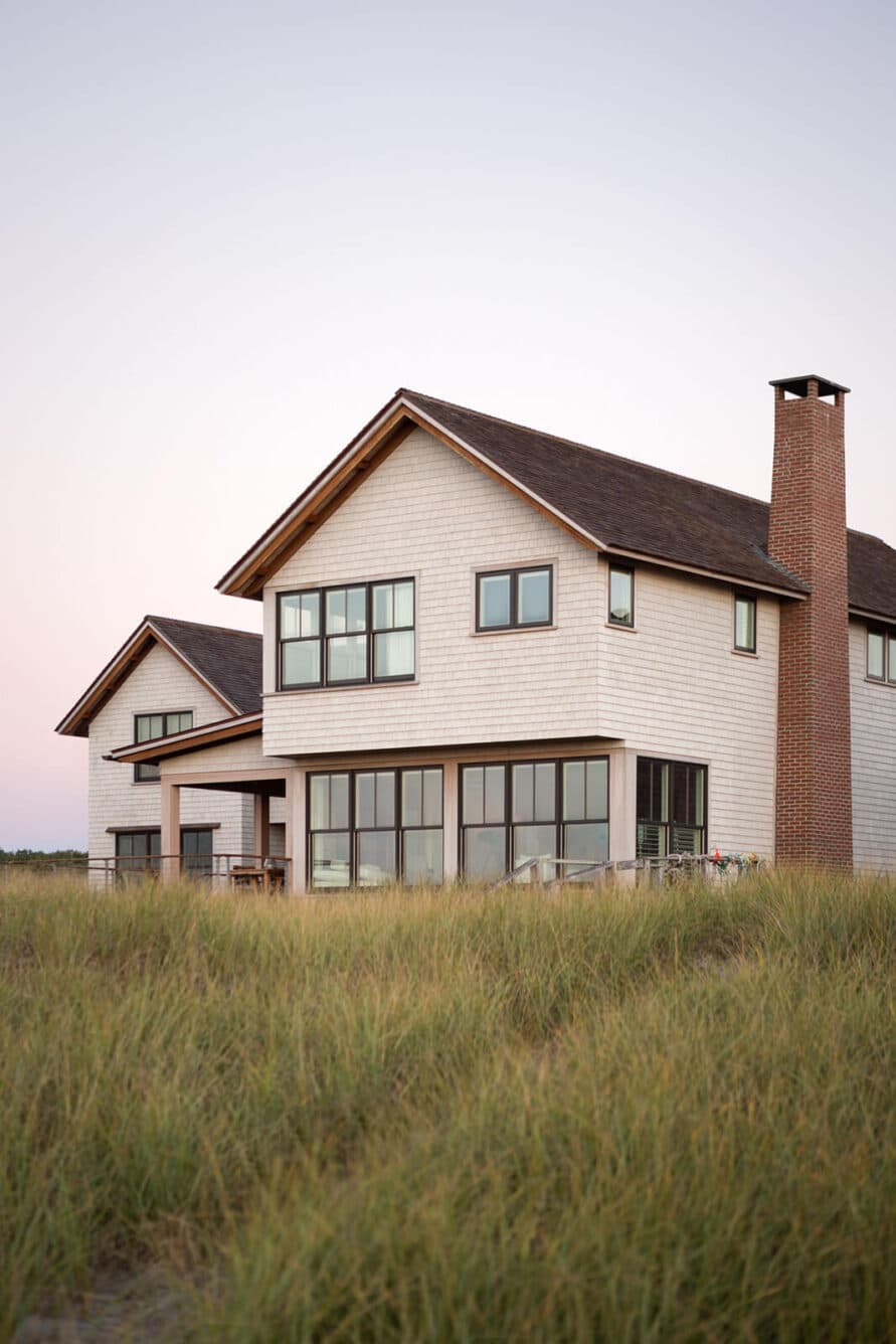 Exterior of Cast On with many windows, a chimney, and long grass in front of the house