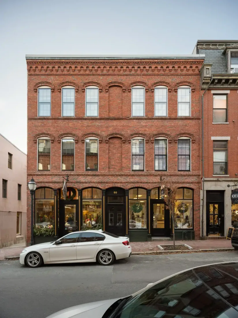 50 Exchange Street’s historic brick façade with arched windows and decorative cornices, housing retail shops at street level