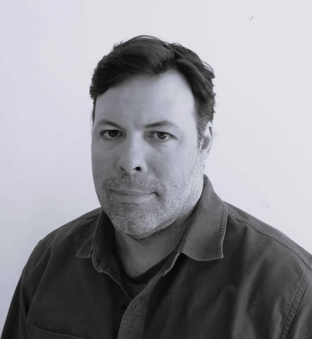 A black and white portrait of Tony DeLorenzo