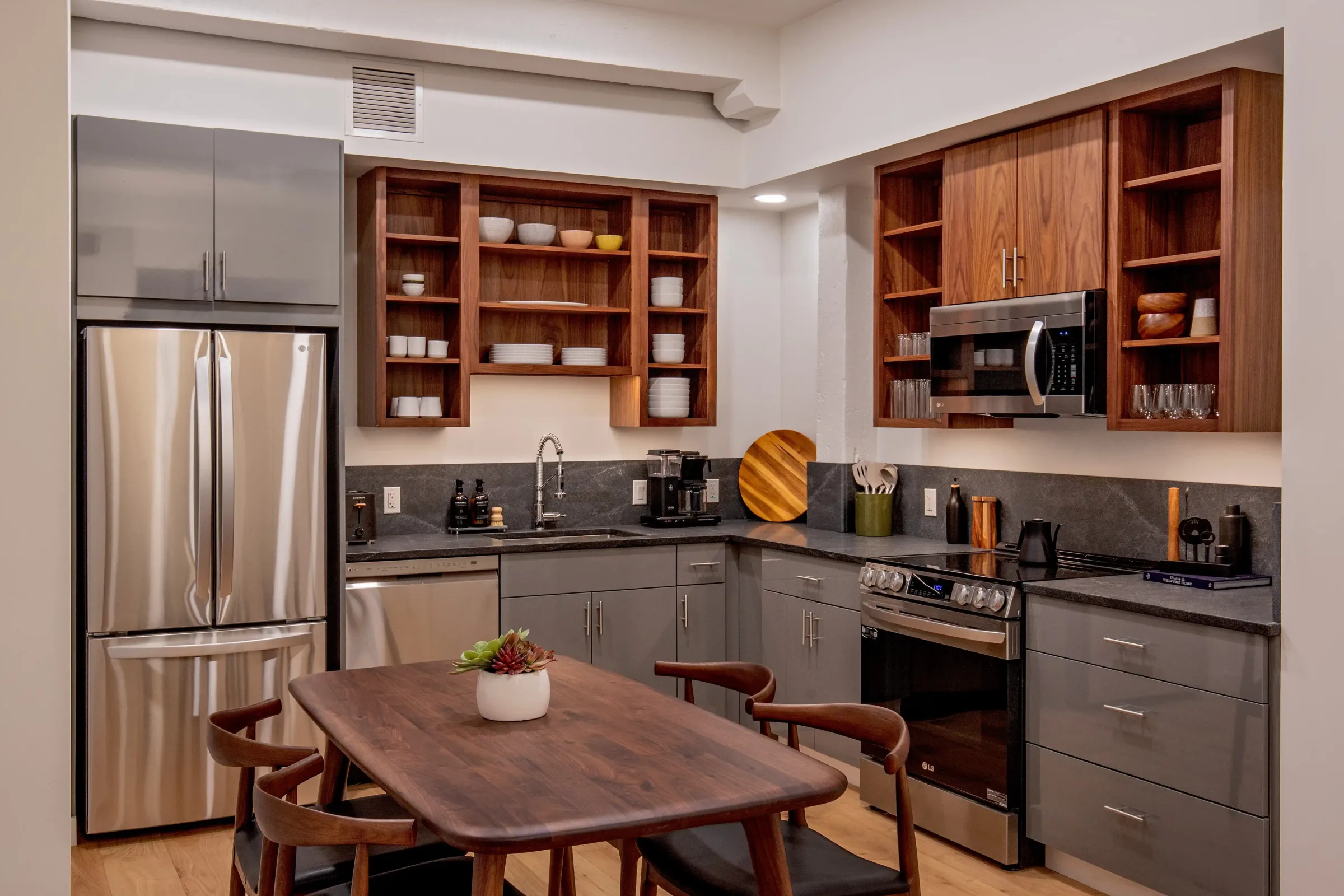Unit 2's kitchen area with shelving and a table at the Weldon Hotel designed by Woodhull