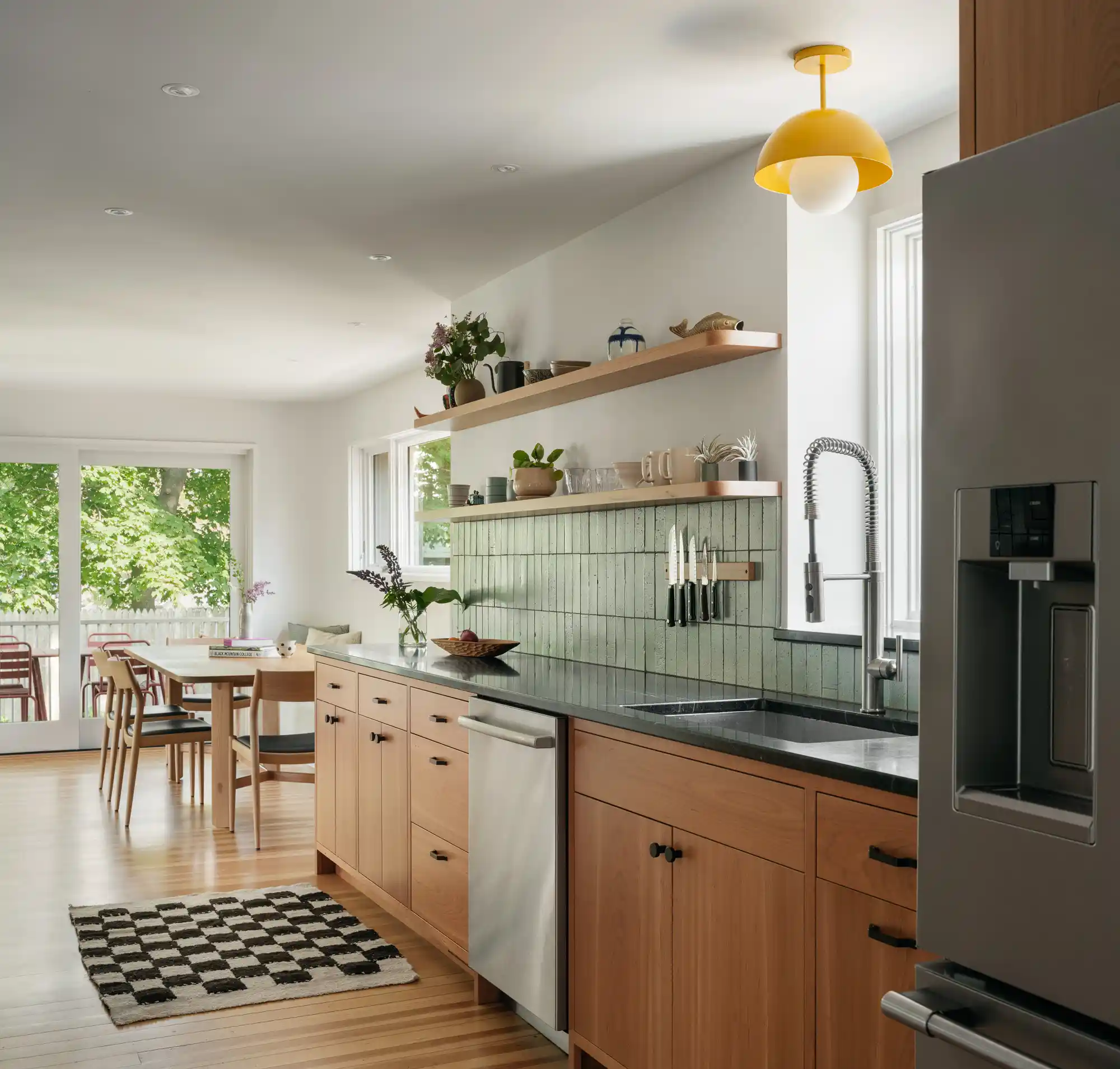 Bright custom kitchen with stained wood cabinets, blue vertical tile backsplash, and open shelving