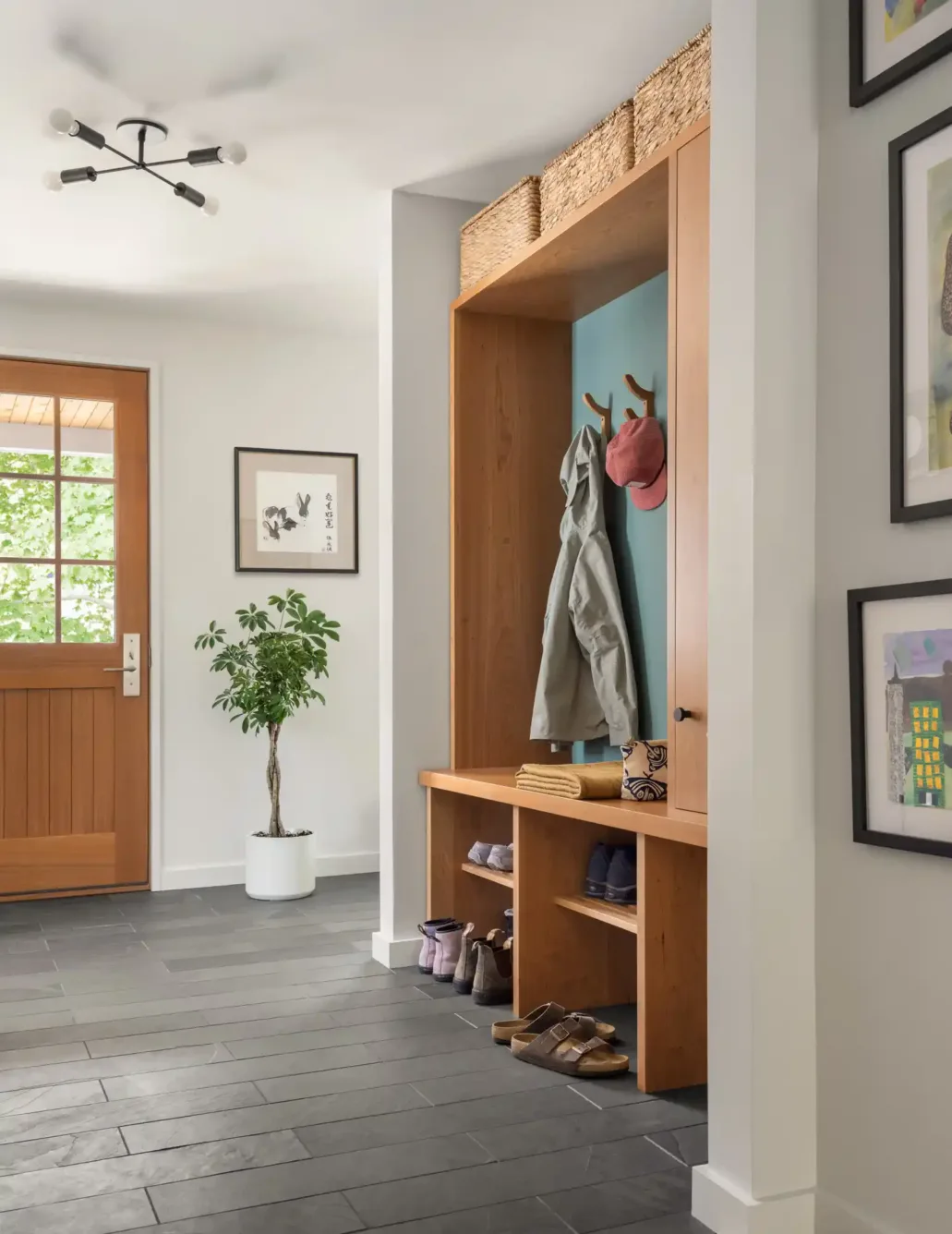 Custom built-in coat and shoe rack in modern entryway of South Portland home renovation