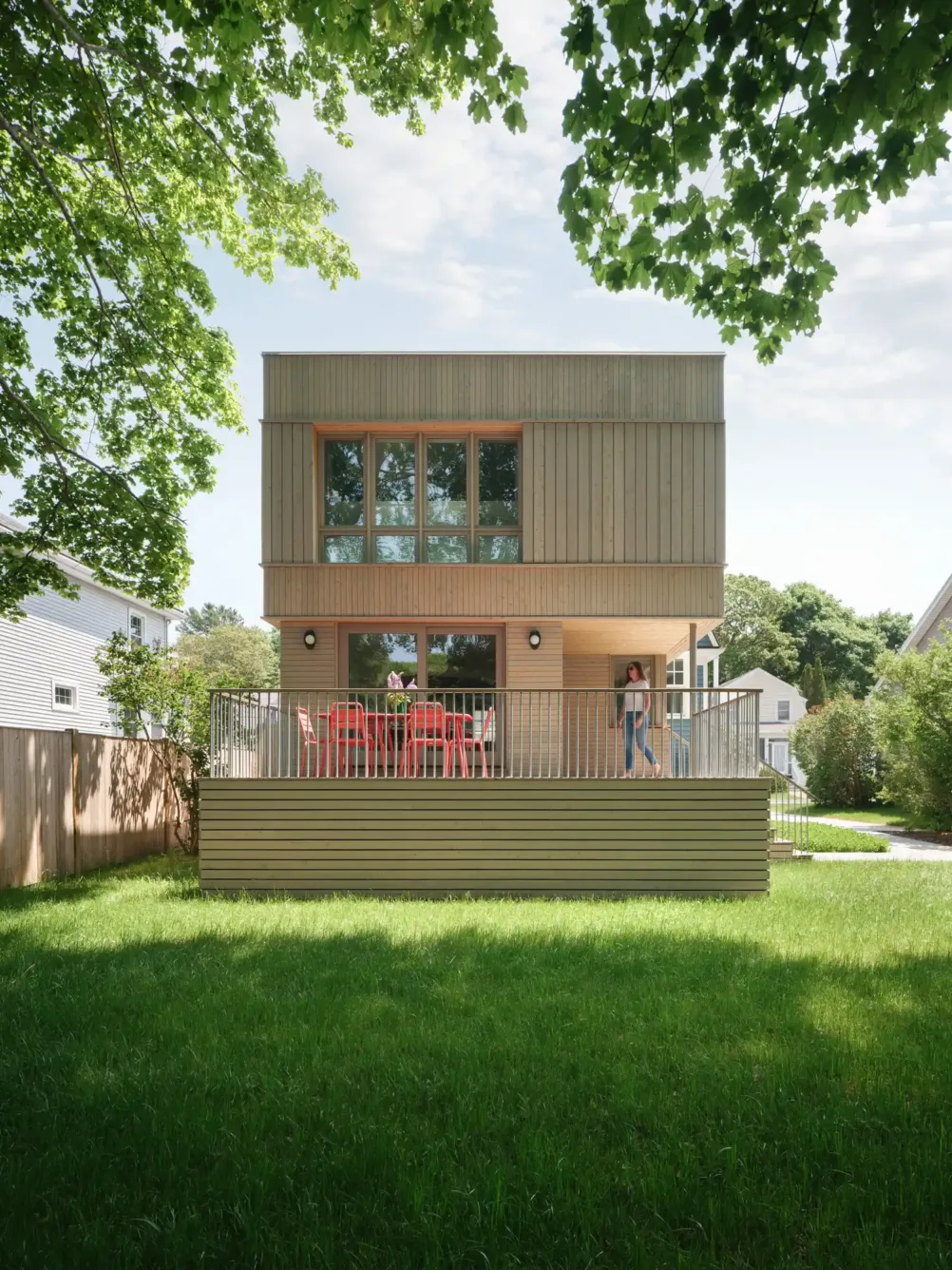 Backyard view of modern cubist home addition with cedar cladding and porch