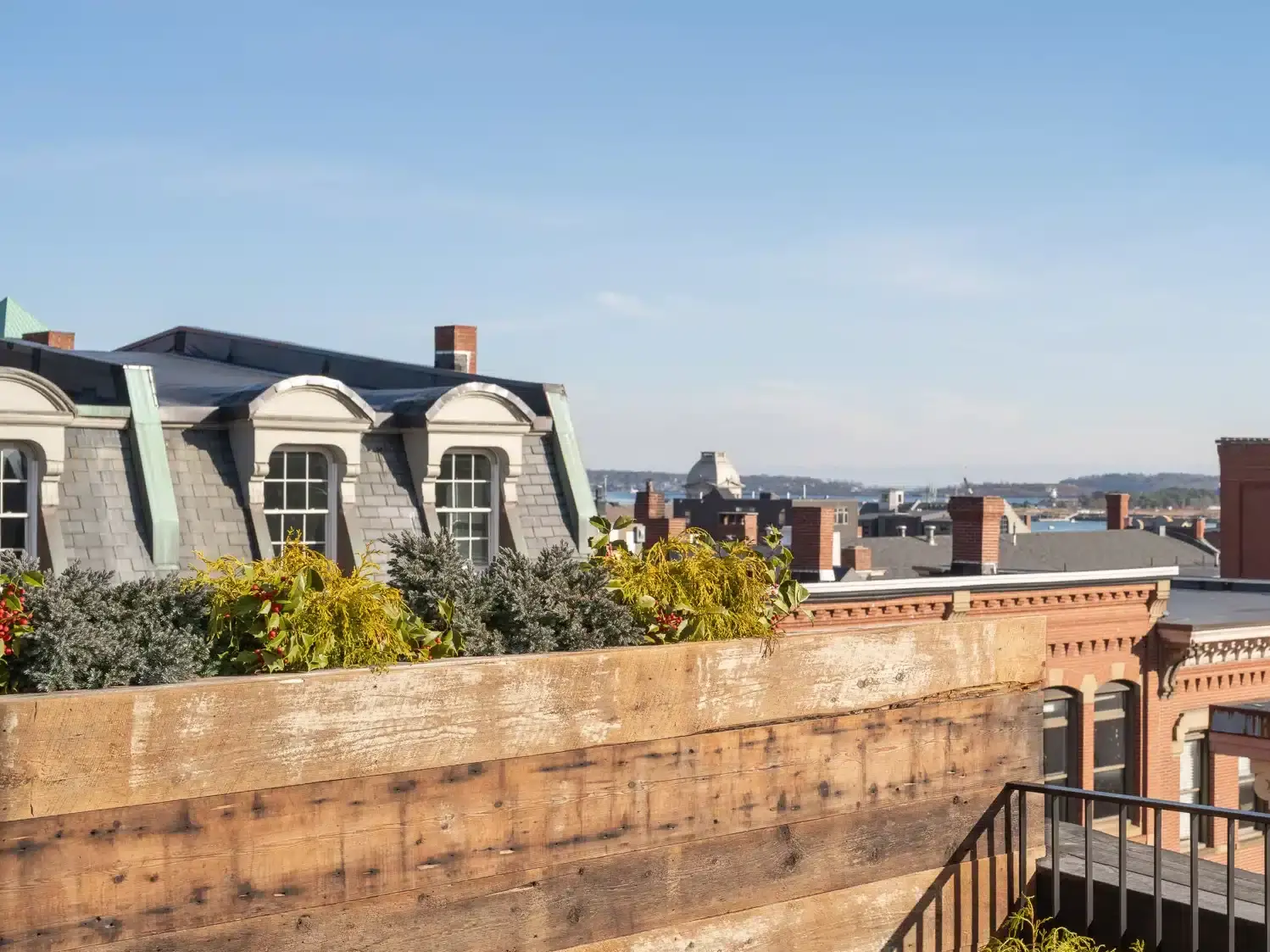 Scenic rooftop view of downtown Portland, Maine with waterfront and city skyline.